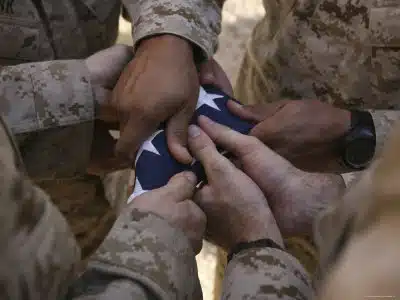 stk102498m_marines-fold-an-american-flag-after-it-was-raised-in-memory-of-a-fallen-soldier-posters_main