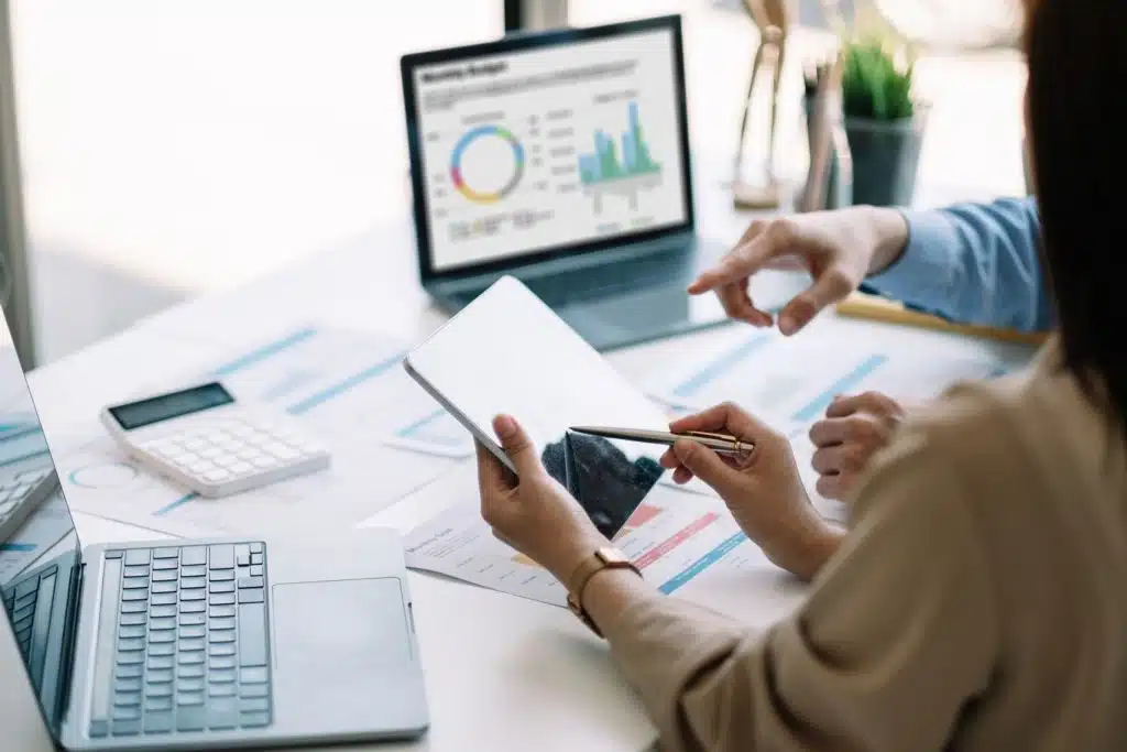 two people sitting at a desk reviewing financial reports in their finance careers as financial analysts jobs