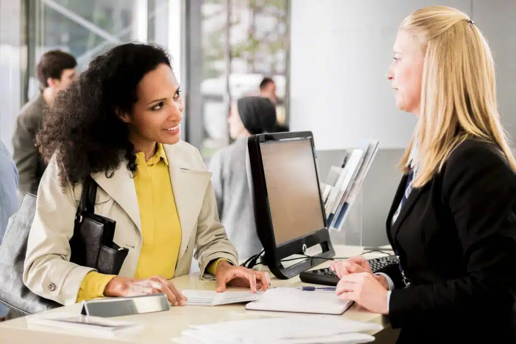 Two women speaking at a counter in an office 